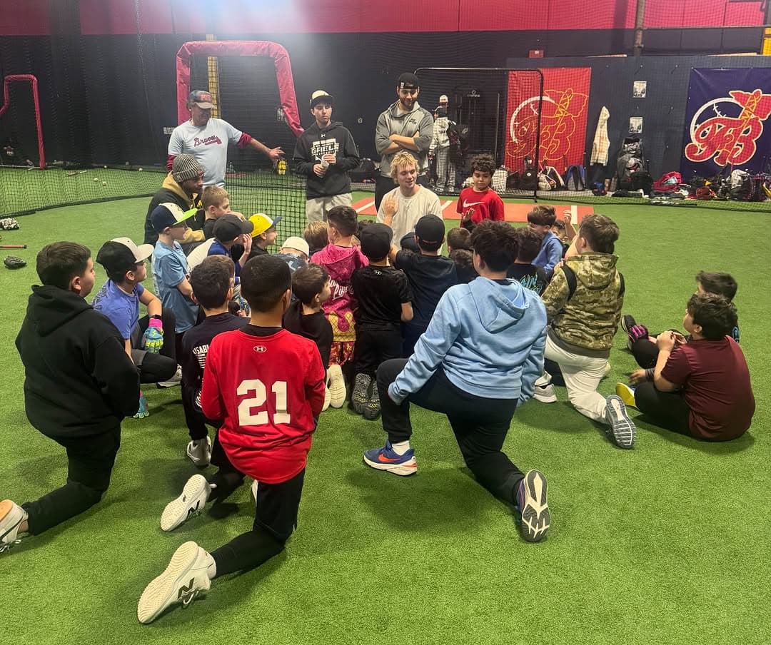 FB Braves coach providing hands-on baseball instruction to players